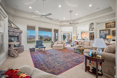 Living area featuring a raised ceiling, carpet, a fireplace, and recessed lighting