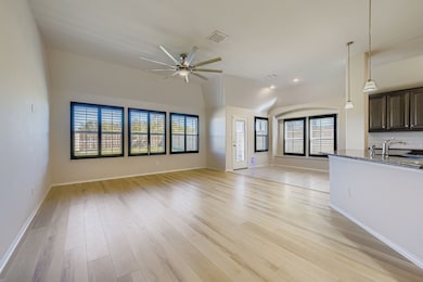Unfurnished living room featuring plantation shutters, light wood-style floors, lofted ceiling, and recessed lighting