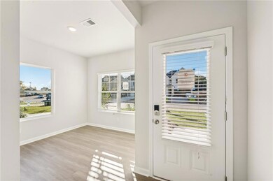 Doorway featuring baseboards, wood finished floors, and recessed lighting