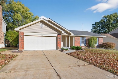 Single story home with brick siding, driveway, and an attached garage