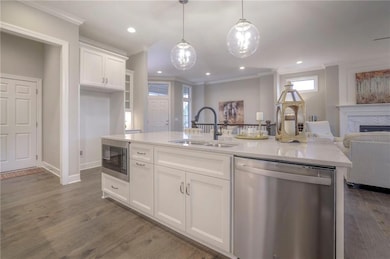Kitchen with an island with sink, white cabinetry, sink, and appliances with stainless steel finishes