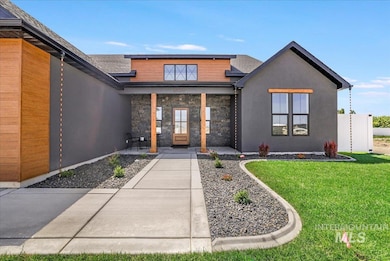Property entrance featuring a lawn, stucco siding, a porch, a shingled roof, and stone siding