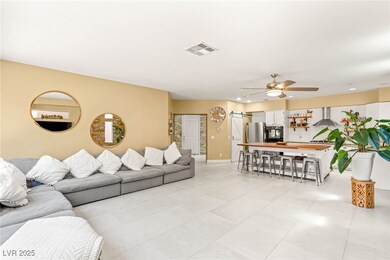 Living room with ceiling fan, a barn door, baseboa