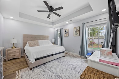 Bedroom with recessed lighting, a raised ceiling, 