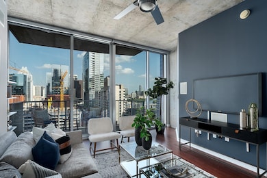 Living room featuring a wall of windows, a ceiling fan, and wood finished floors