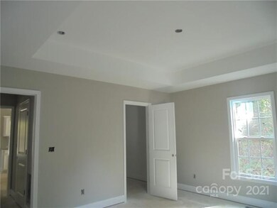 Primary Bedroom with treyed ceilings, large walk-i