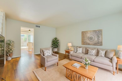 Living room featuring visible vents, baseboards, 
