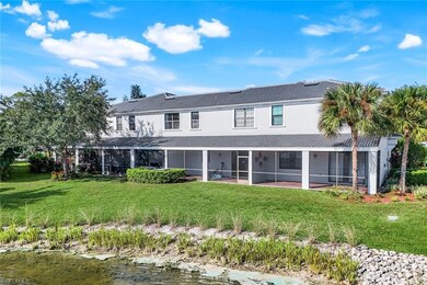 Back of house with a yard, a water view, a sunroom, and a tiled roof
