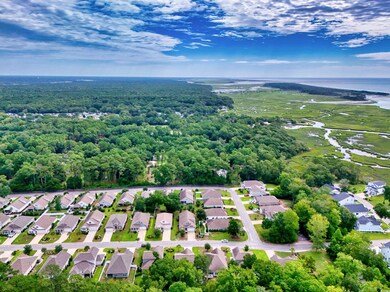 Aerial view of residential area featuring a nearby body of water and a forest