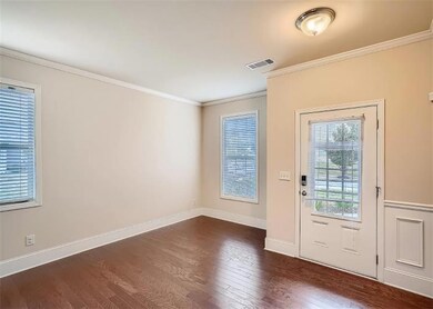 Entryway featuring dark wood finished floors, ornamental molding, and baseboards
