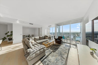 Living room featuring floor to ceiling windows and light wood finished floors