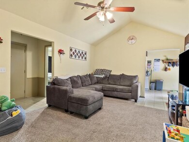 Tiled living room featuring vaulted ceiling and ce