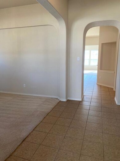 Unfurnished room with arched walkways and tile pa