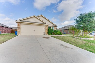 View of front of home with central AC, a garage, a