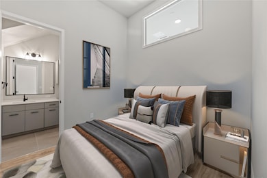 Bedroom featuring a sink, light wood finished flo