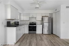 Kitchen featuring white cabinets, appliances with stainless steel finishes, light countertops, a ceiling fan, and light wood finished floors