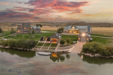 Aerial view of property with boathouse, outdoor entertaining area, main home, and hangar