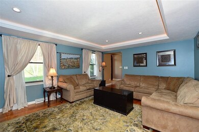 The living room features a tray ceiling with accen