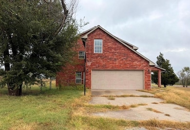 View of property exterior with brick siding, driveway, and a garage