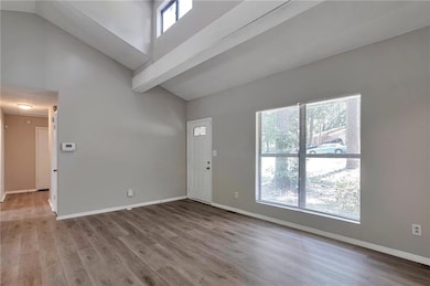 Foyer featuring wood finished floors and high vaulted ceiling