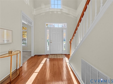 Bright two-story foyer with hardwood floors and abundant natural light welcomes you into the home.