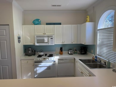 Kitchen featuring white cabinetry, sink, and white