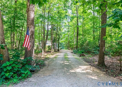 View of dirt / gravel road featuring a wooded view