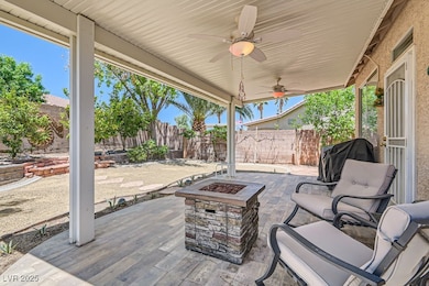 Fenced backyard featuring a fire pit, a patio area, a ceiling fan, and a grill