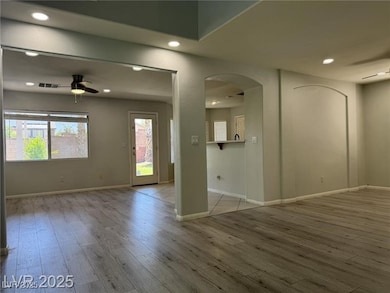 Empty room featuring a ceiling fan, arched walkway