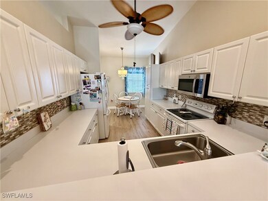 Kitchen featuring white appliances, a sink, backsp