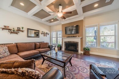 Great Room has gas log fireplace and coffered ceiling! (note: small wall shelves do not convey)