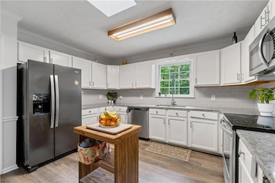 Kitchen with SS appliances, white cabinets and granite countertops
