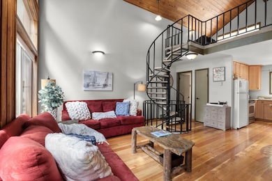 Living area featuring wooden ceiling, high vaulted ceiling, stairway, and light wood-type flooring