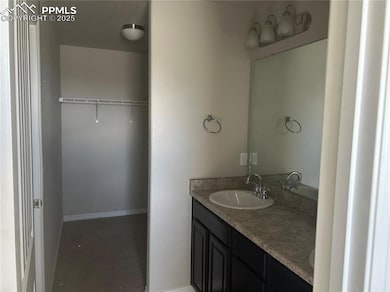 Full bathroom with double vanity and a walk in closet