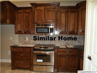 Kitchen features custom cabinets with raised panel doors, stainless appliances, granite counter tops, tile back splash, recessed lighting. Picture from similar home.