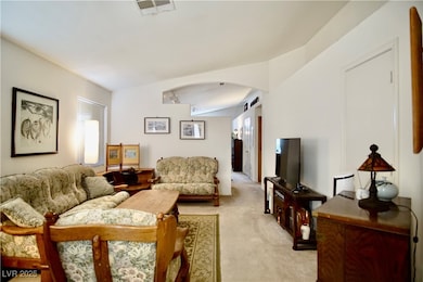 Living area with light carpet, plenty of natural l