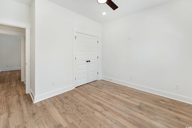 Unfurnished bedroom featuring light wood-style flooring, a closet, recessed lighting, and ceiling fan