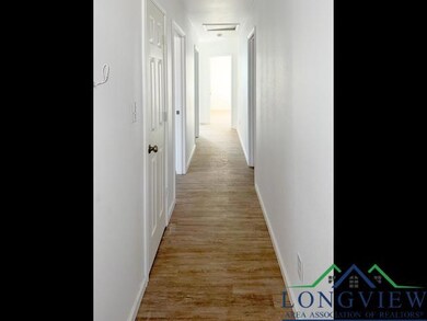 Hallway featuring light wood-style floors and baseboards