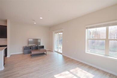 Living area with light wood-style floors, baseboa