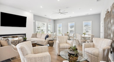 Living area featuring healthy amount of natural light, recessed lighting, a ceiling fan, light wood-style floors, and a fireplace