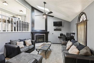 You will love the living area featuring vaulted ceiling, a tile fireplace, a skylight, and a ceiling fan