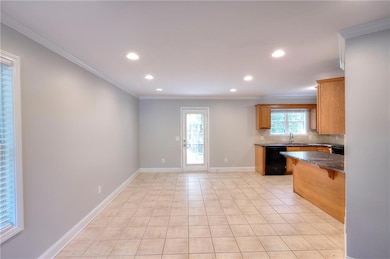 Kitchen featuring crown molding, backsplash, light tile patterned floors, recessed lighting, and dark stone countertops