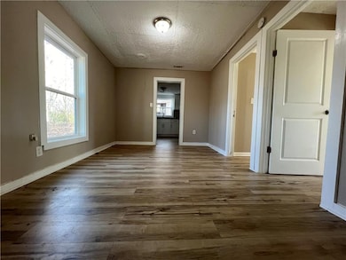 Spare room with a textured ceiling, wood finished 