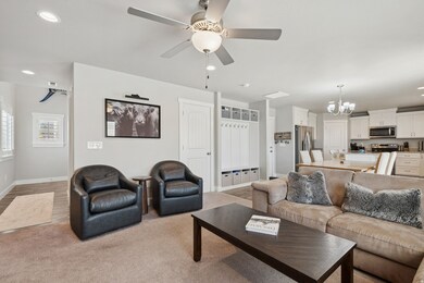 Living room with a chandelier, recessed lighting, a ceiling fan, light wood finished floors, and light colored carpet