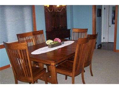 Large dining room with chandelier, newer carpet, a