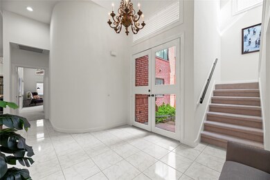 Light filled two story entry viewed toward 1st floor primary bedroom.