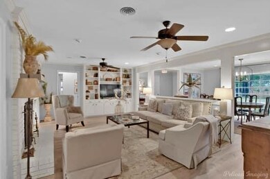 Living room with crown molding and ceiling fan wit