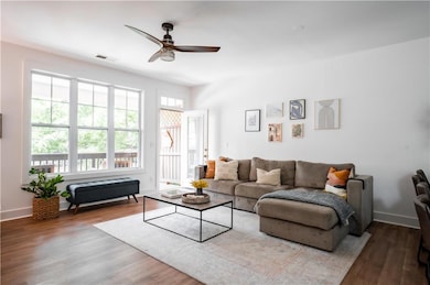 Living area featuring ceiling fan, wood finished floors, and baseboards