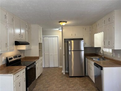 Kitchen with sink, white cabinetry, and stainless 