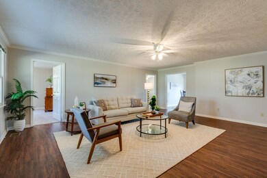 Living space with doorways to two bedrooms and the kitchen eat in area. 